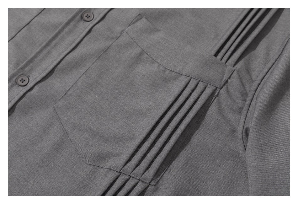 Close-up of a gray shirt's chest pocket, button placket, and parallel pleated detailing.