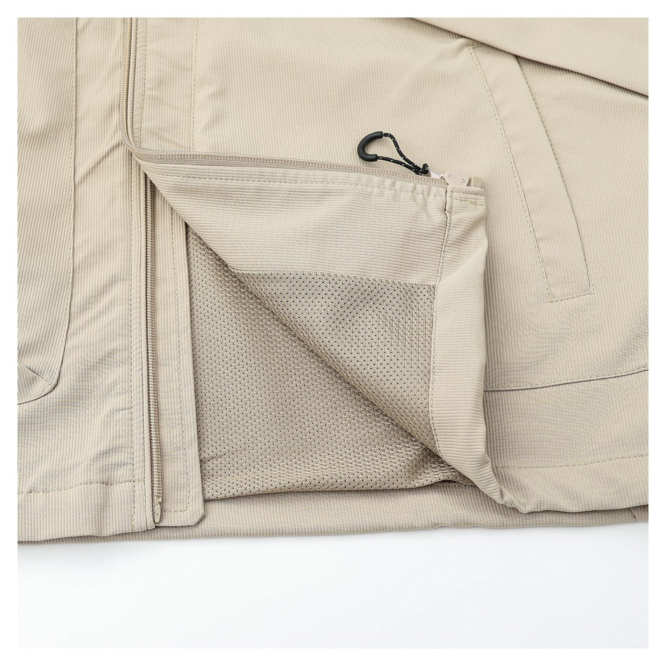 Close-up of the beige vest with a zippered pocket opened to show its mesh lining.