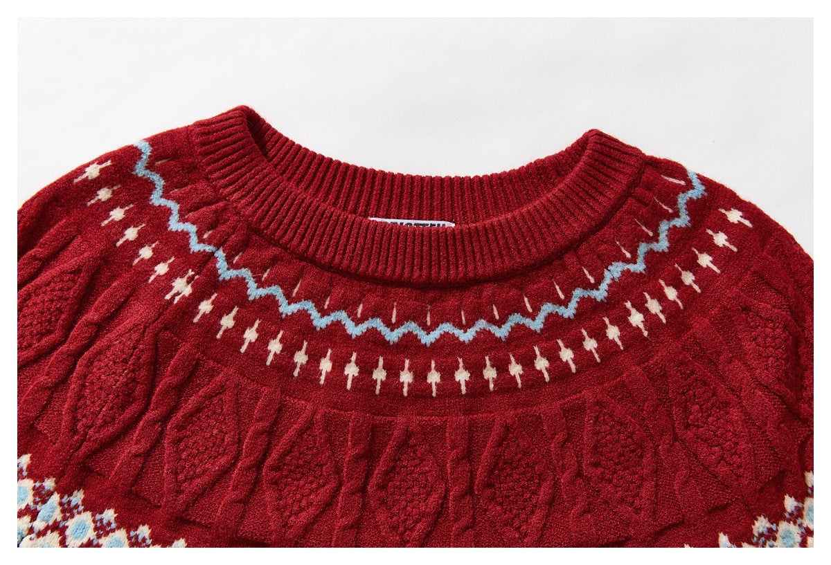 Close-up of a red sweater neckline with ribbed crew neck, textured cable-knit yoke, and cream and blue geometric bands.