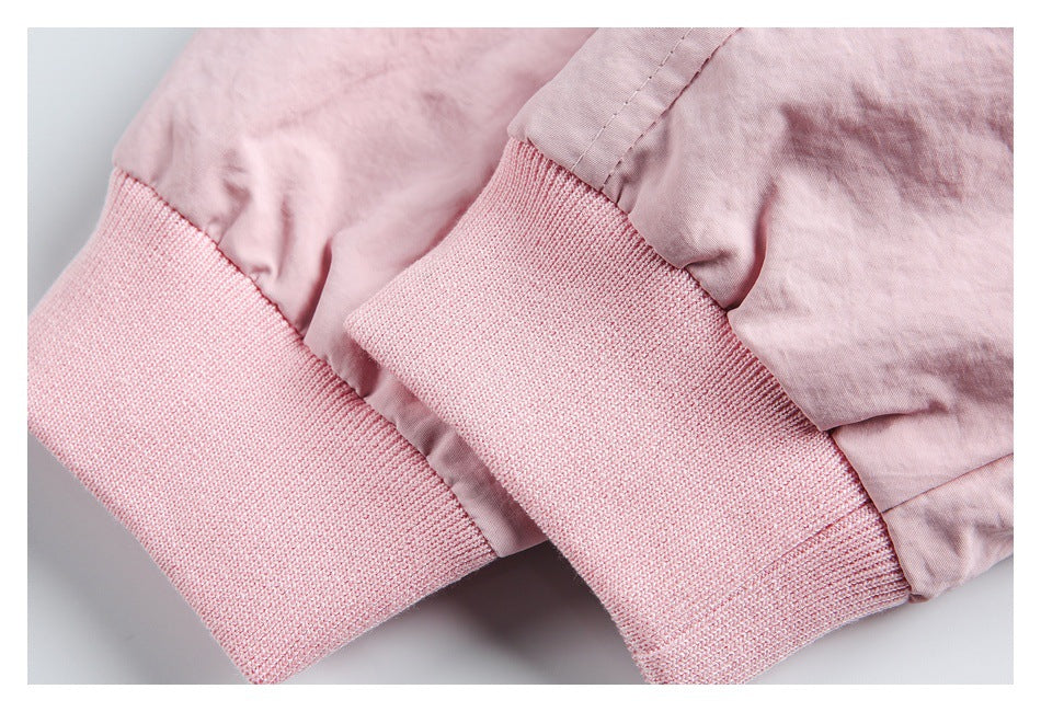 Close-up of pale pink jacket sleeves with wide, ribbed knit cuffs.