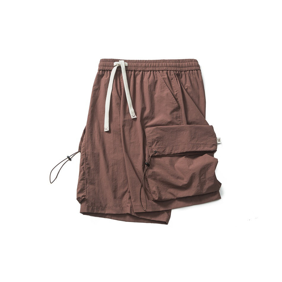 Dusty mauve shorts laid flat, with an elastic waist, white drawcord, and large flap cargo pocket.
