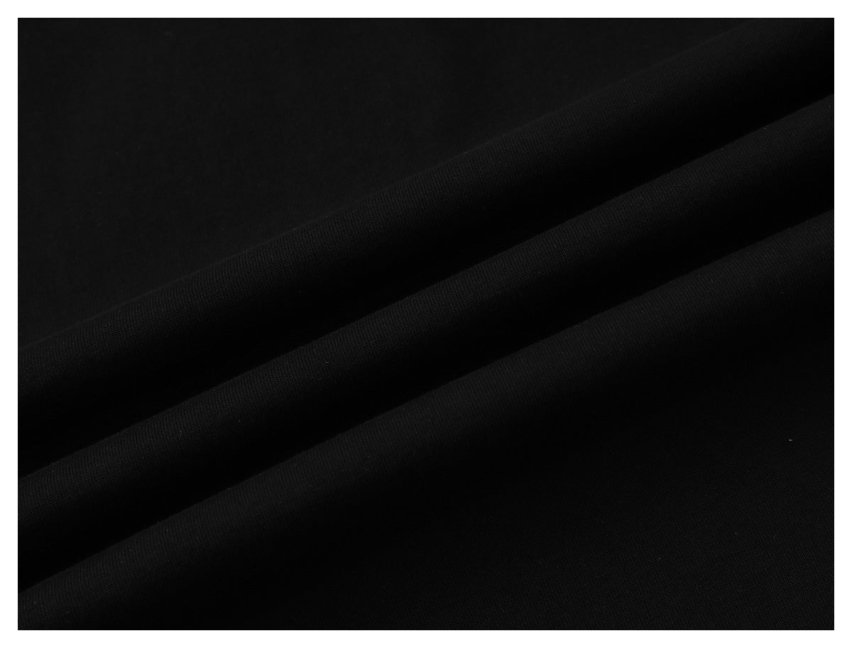 Close-up of black fabric arranged in soft folds, showing its surface texture.