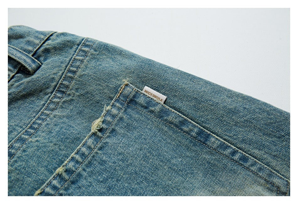 Close-up of a faded blue denim back pocket with fraying and a small sewn label.