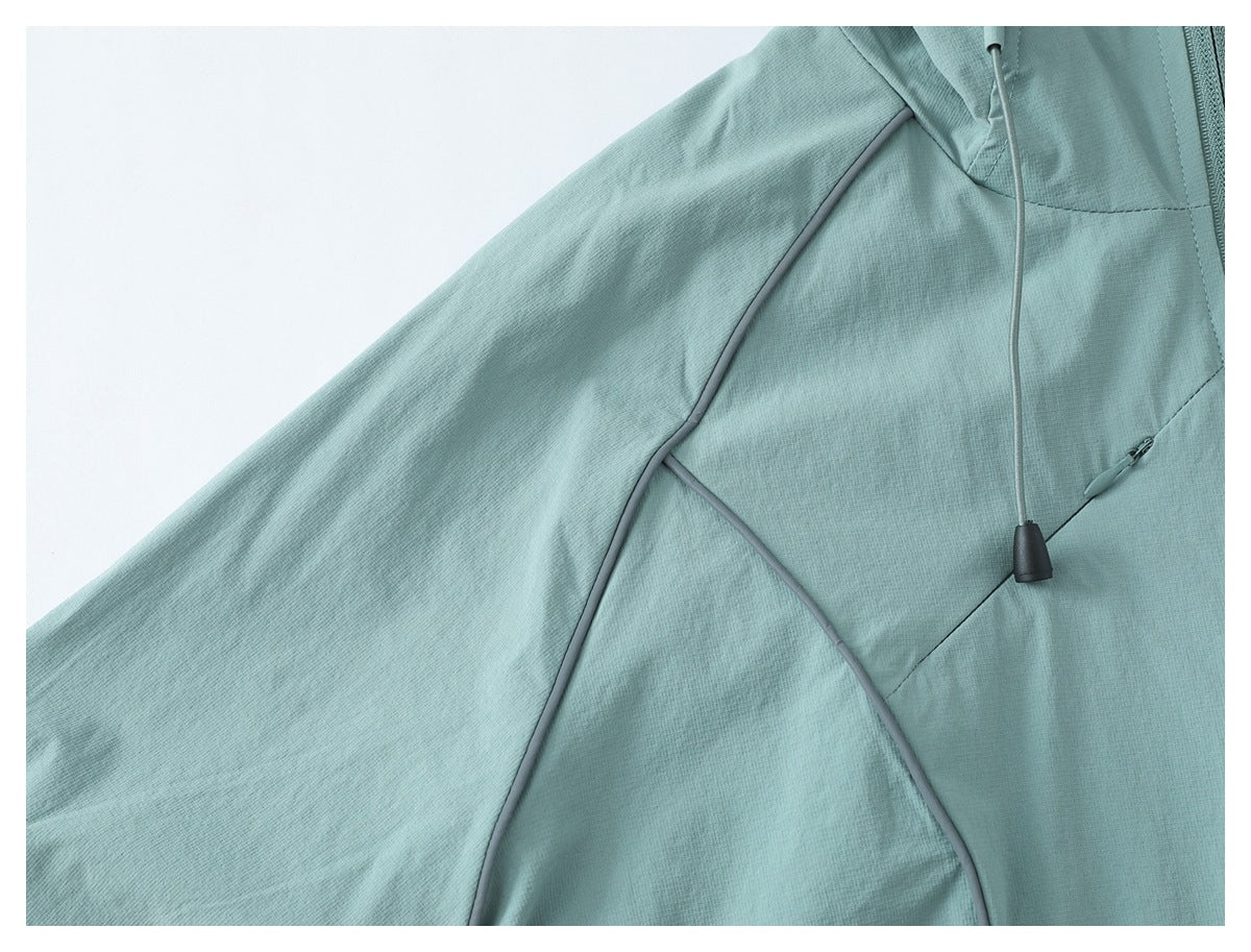 Close-up of a pale teal jacket sleeve and body with gray piping and a drawcord.