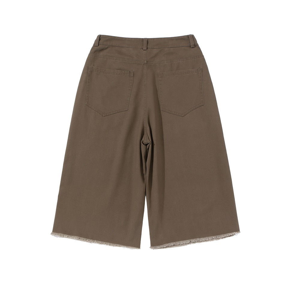 Back view of brown wide-leg shorts with two patch pockets and frayed hems.