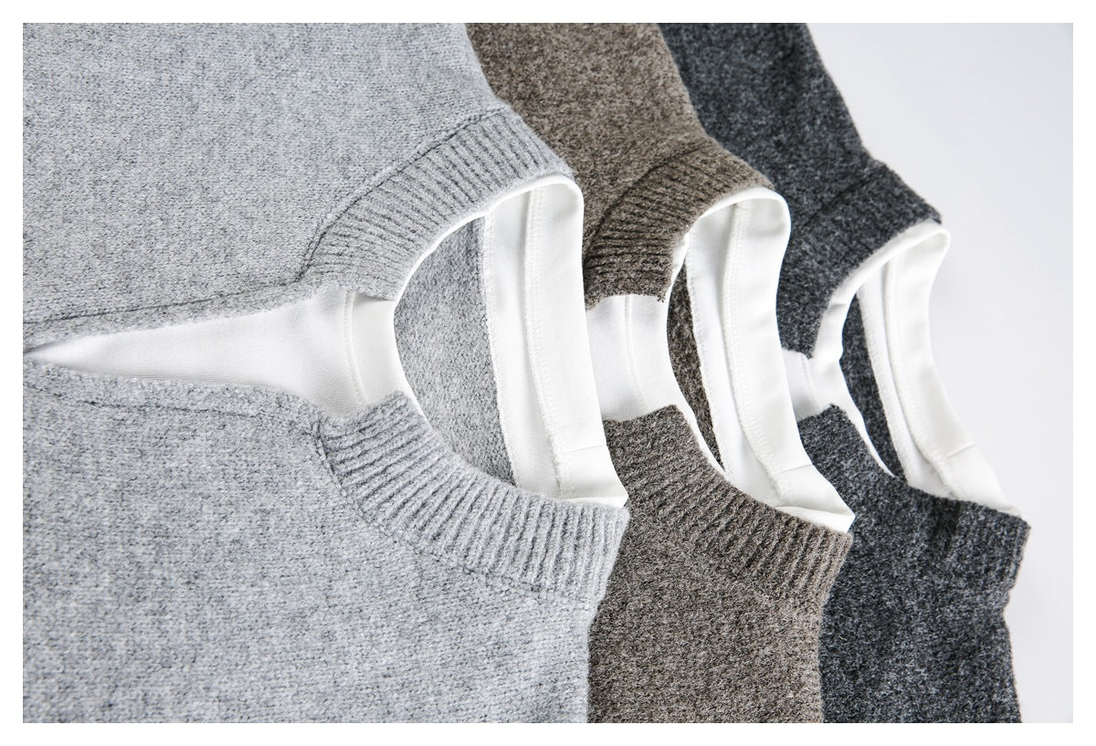 Close-up of three knit sweaters in light gray, brown, and charcoal, showing their white-lined neck openings.