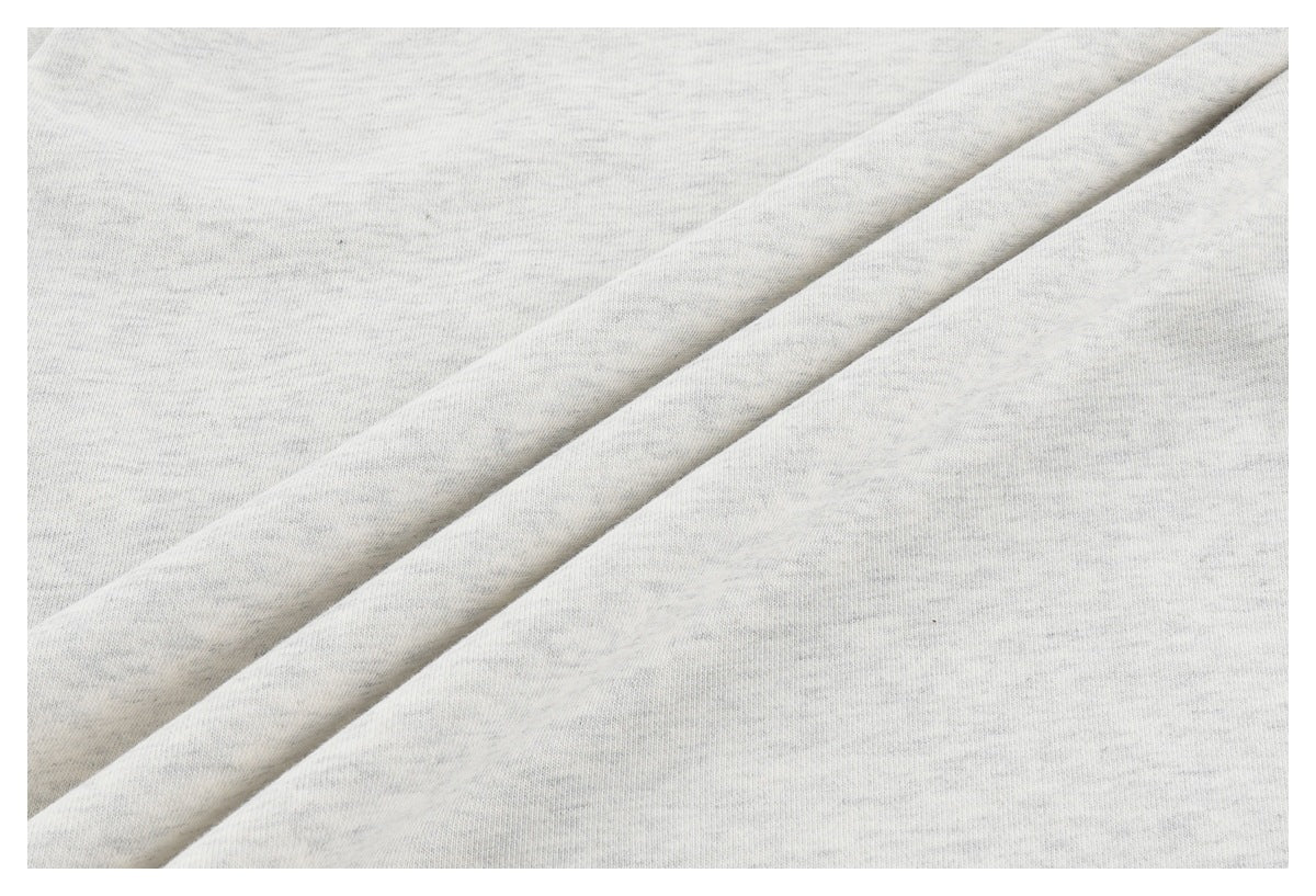 Close-up of light heather gray fabric arranged in diagonal folds.