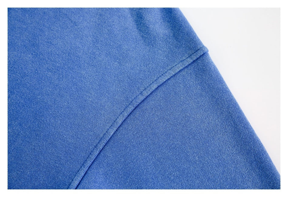 Close-up of blue sweatshirt fabric and a curved stitched seam.