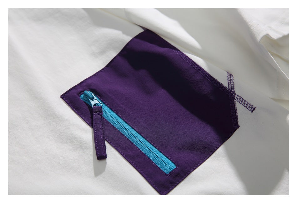Close-up of a deep purple chest pocket with a bright blue zipper on a white shirt.