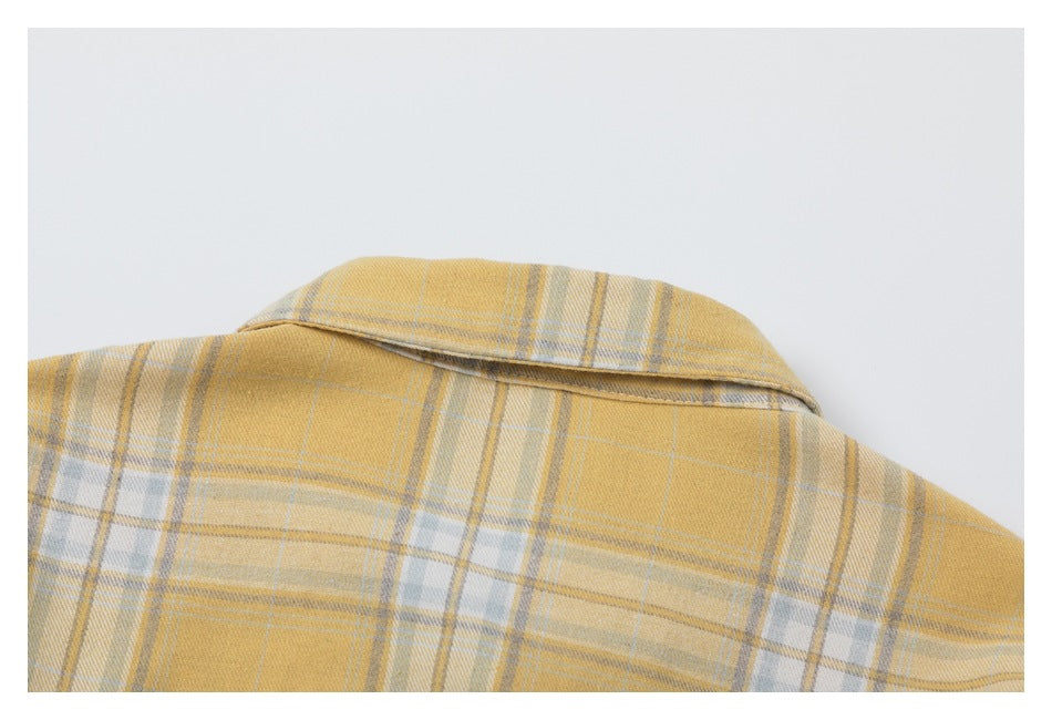 Close-up of the collar and upper back of a mustard yellow plaid shirt.