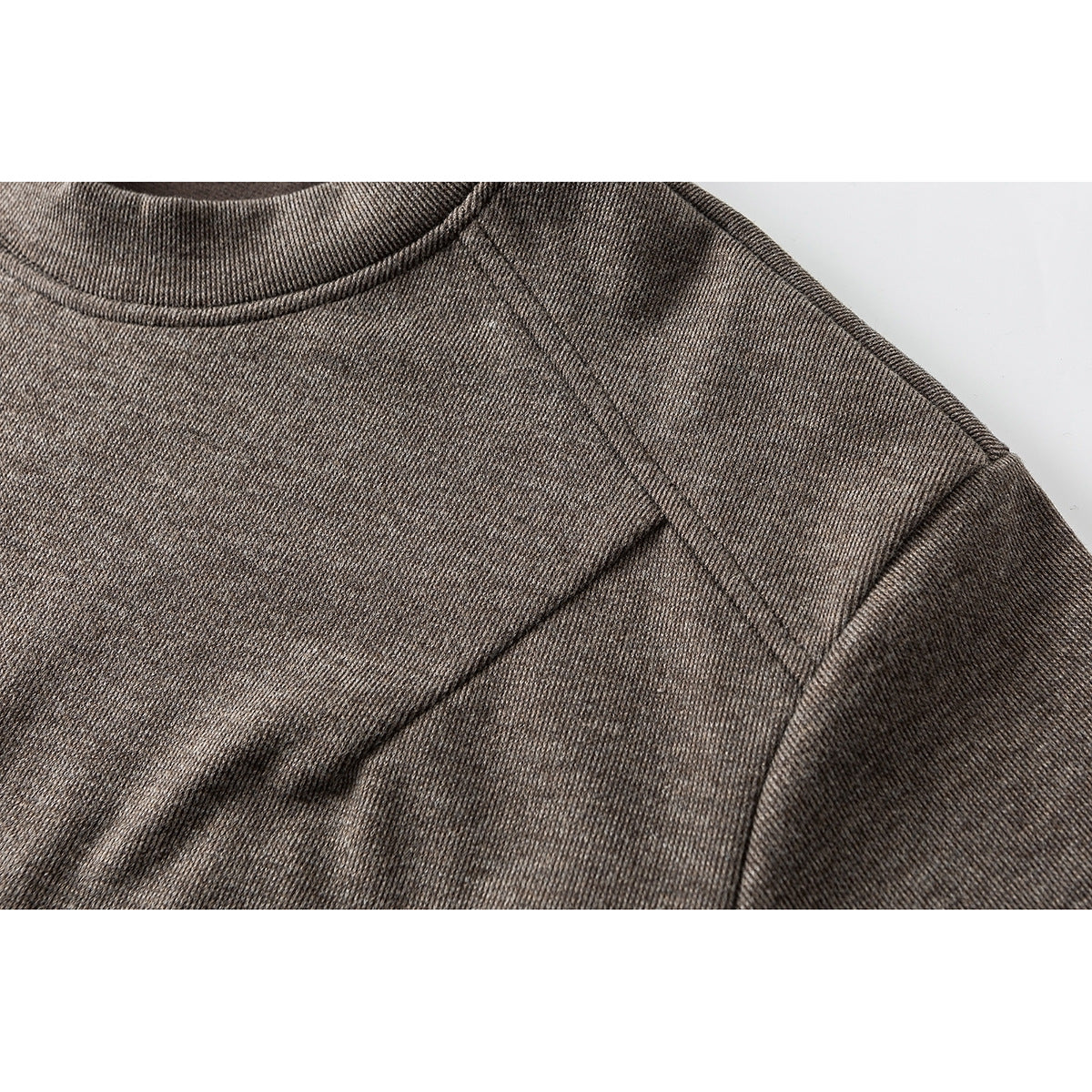 Close-up of a taupe heathered shirt's mock neck and raglan shoulder seams.