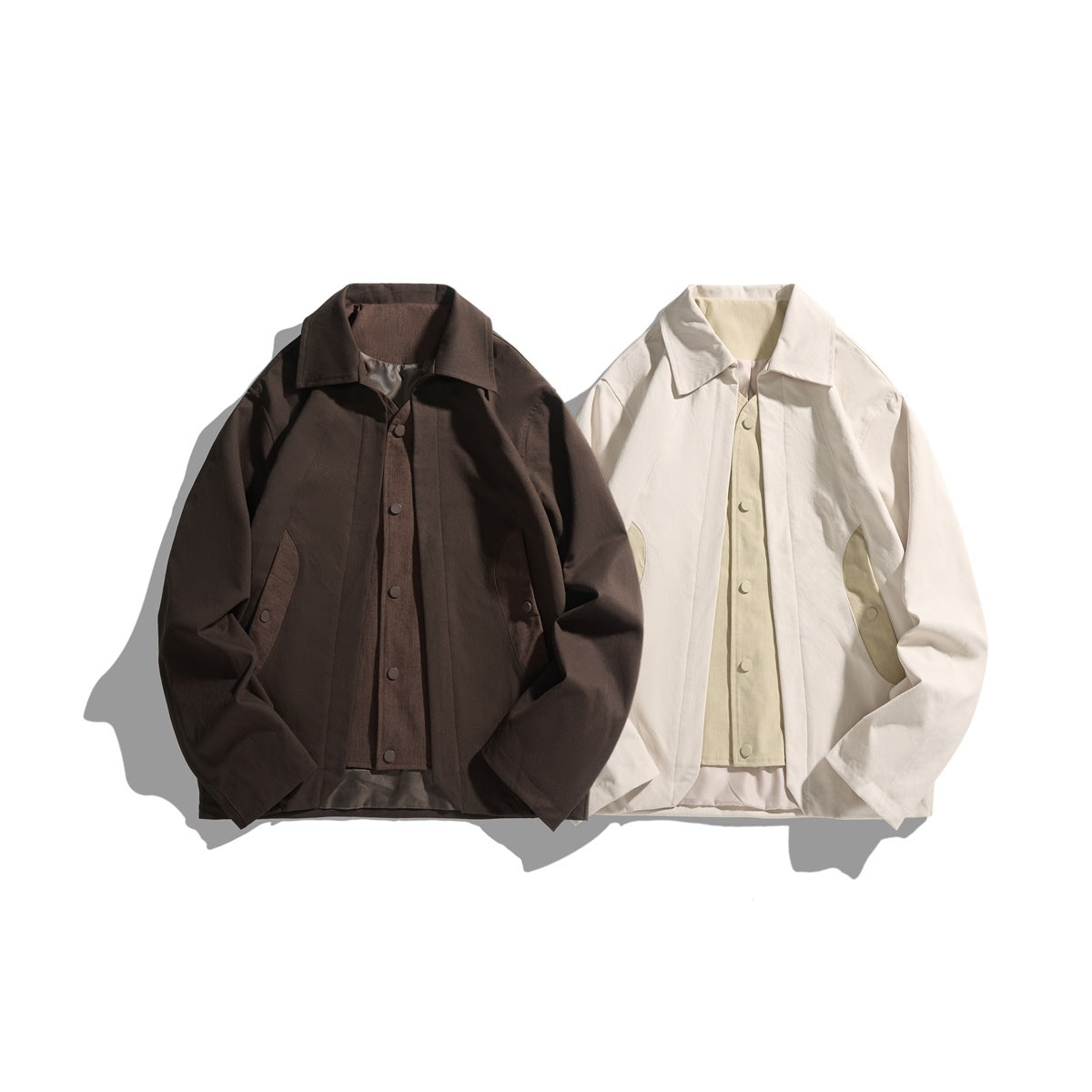 Two jackets displayed side by side: dark brown and cream, each with a pointed collar, snap front and angled pockets.