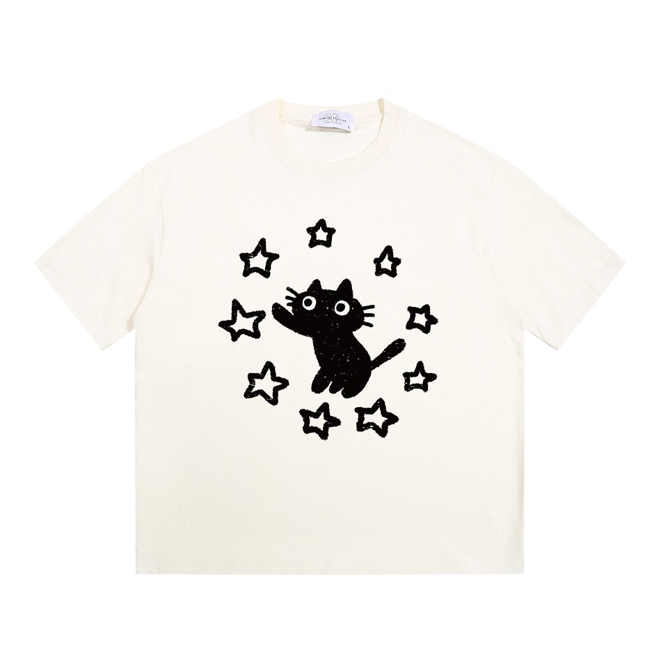 Apricot cream short-sleeve crew-neck T-shirt with a black cat and stars graphic on the chest, flat lay