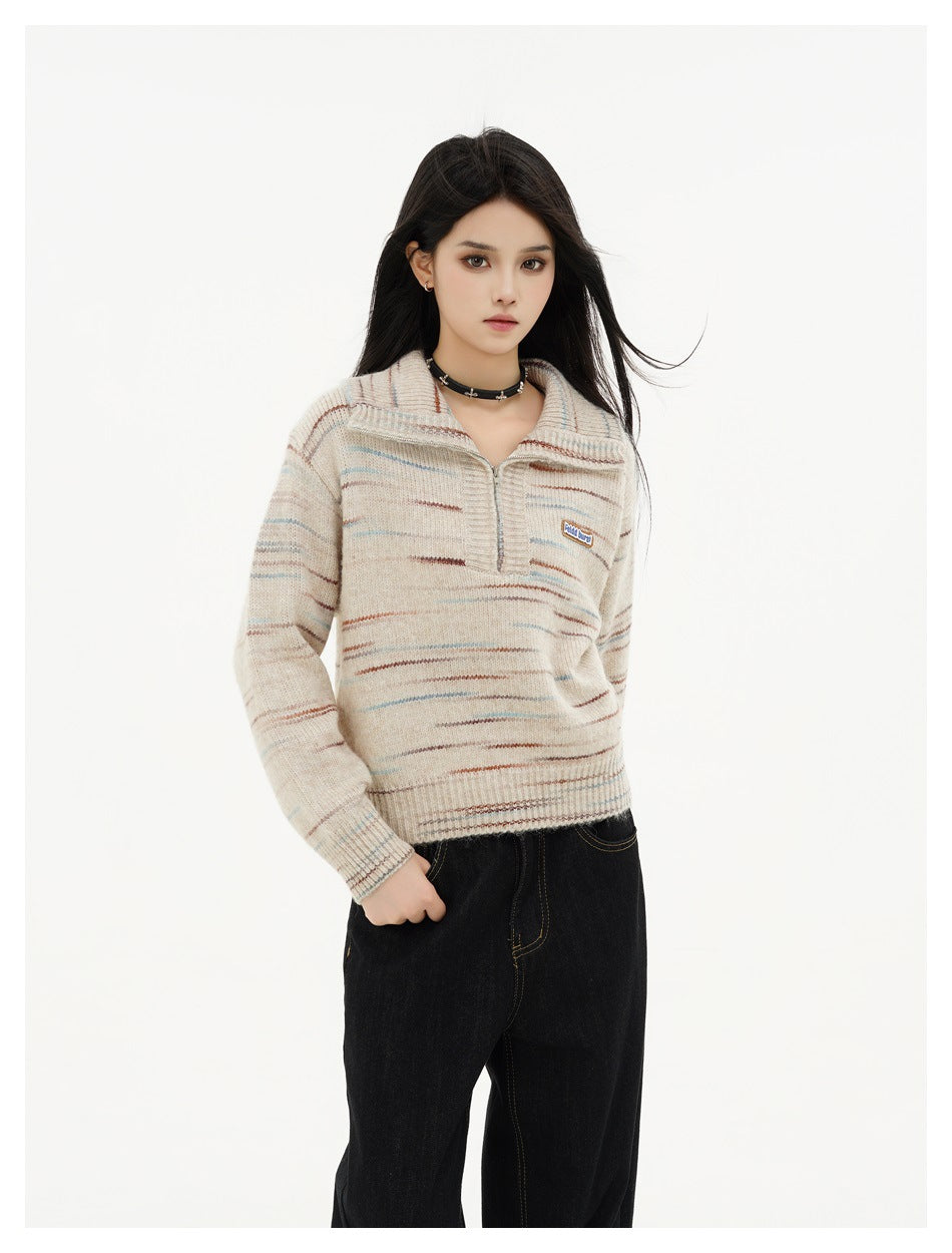 Model wearing a beige streaked half-zip sweater with folded collar and black jeans, full front view