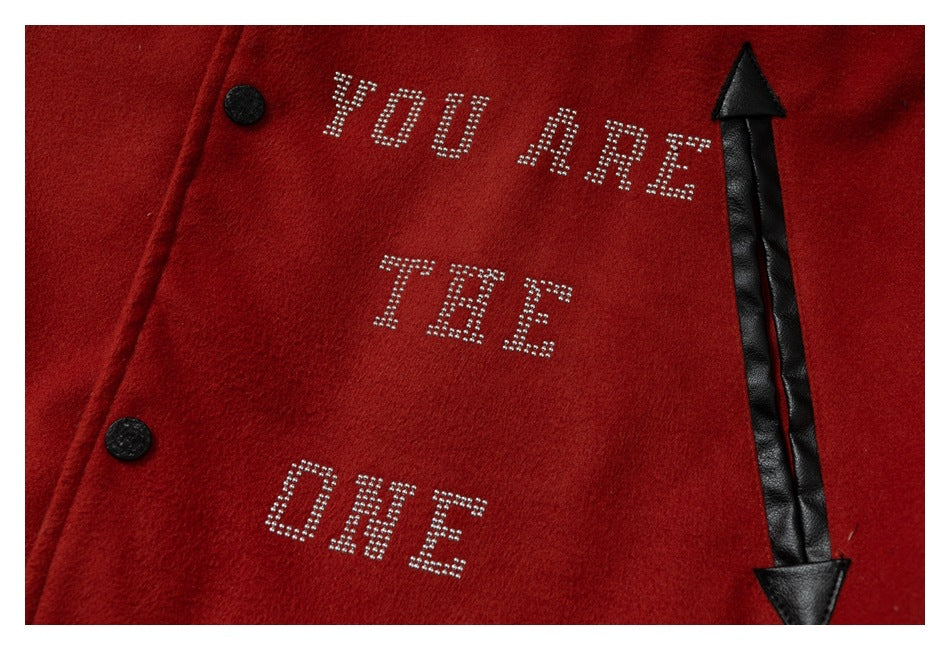 Close-up of a red jacket with rhinestone text reading “YOU ARE THE ONE,” black snaps, and a black arrow appliqué.