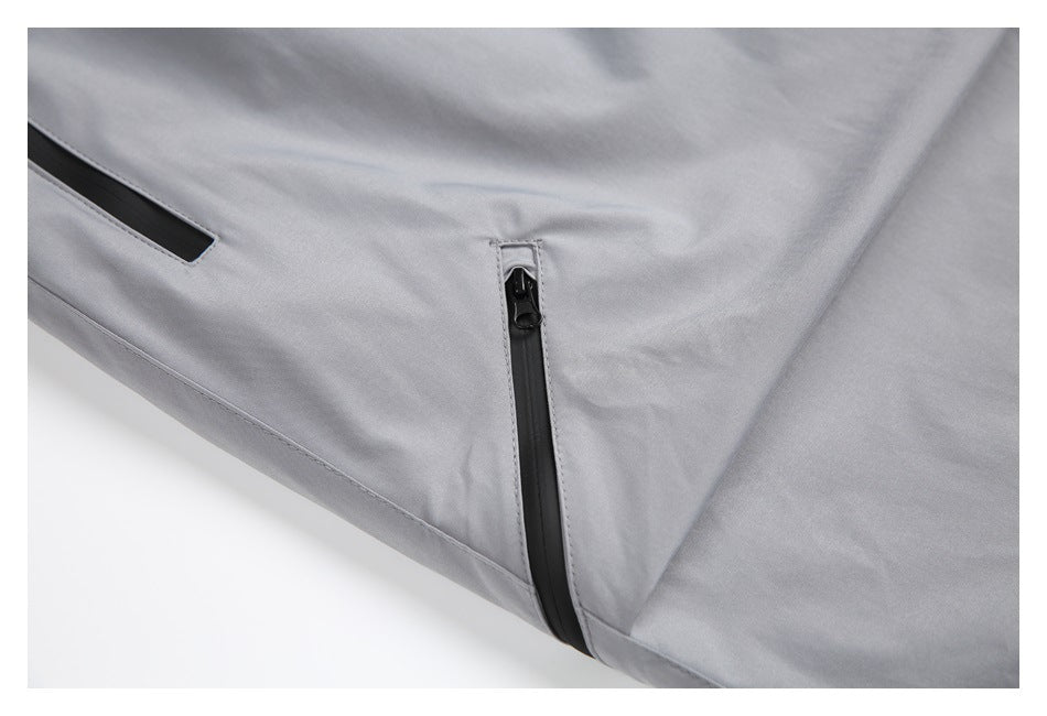 Close-up of two black zip pockets and stitched seams on light gray pants.