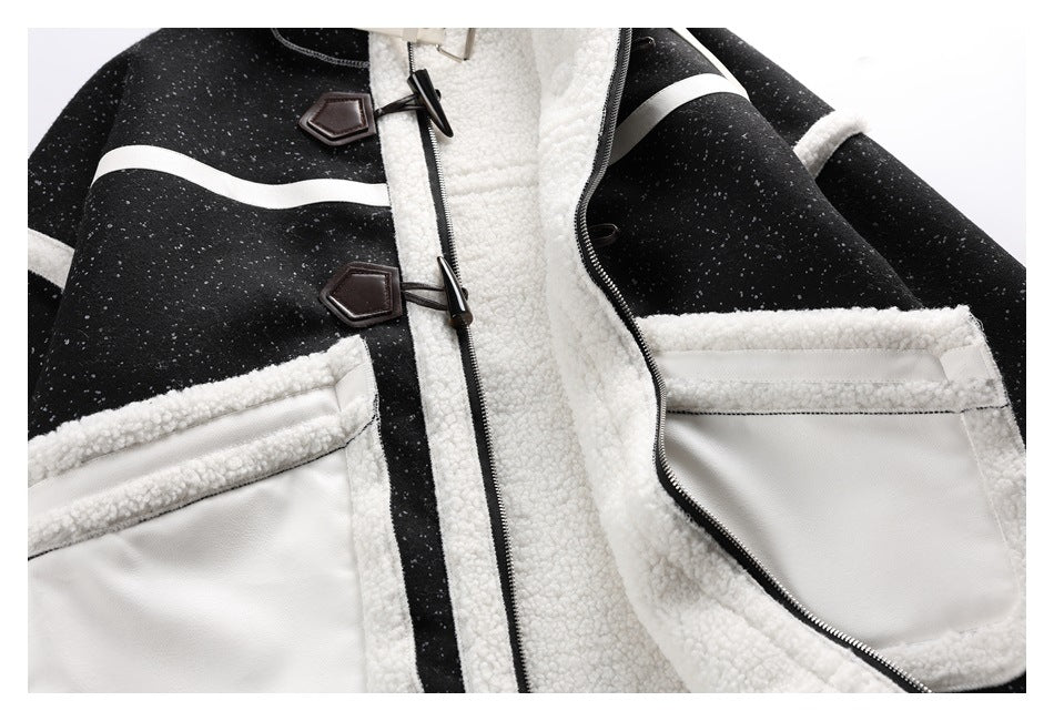 Close view of the black speckled jacket front with white trim, two pockets, zipper, and dark toggle closures.