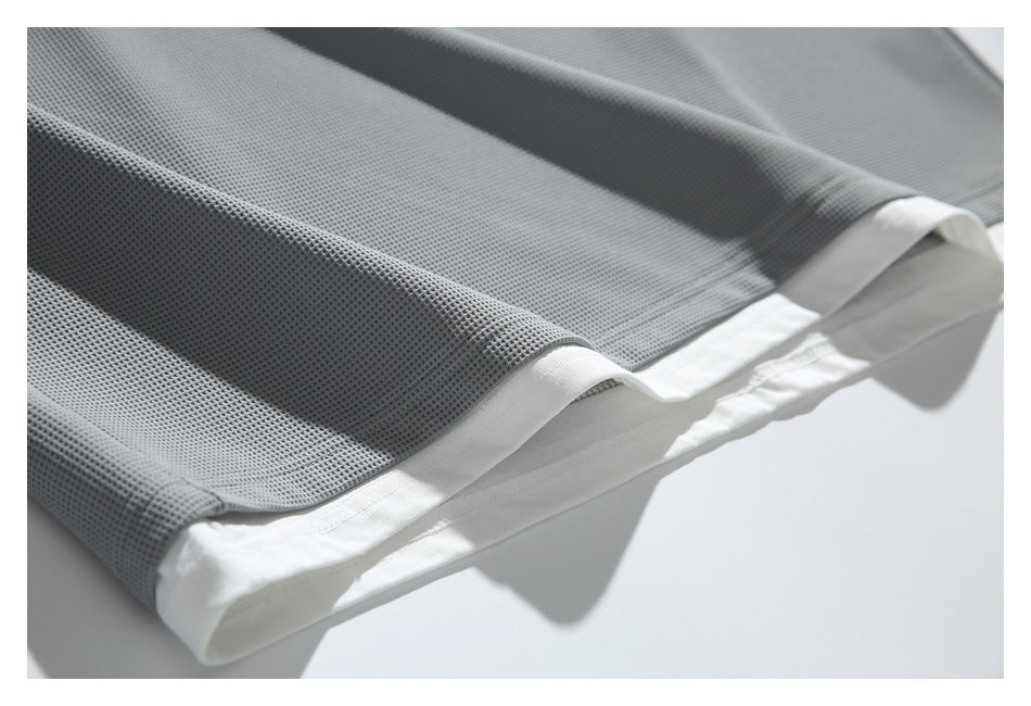 Close-up of gray textured fabric folded over a white hem or lining.