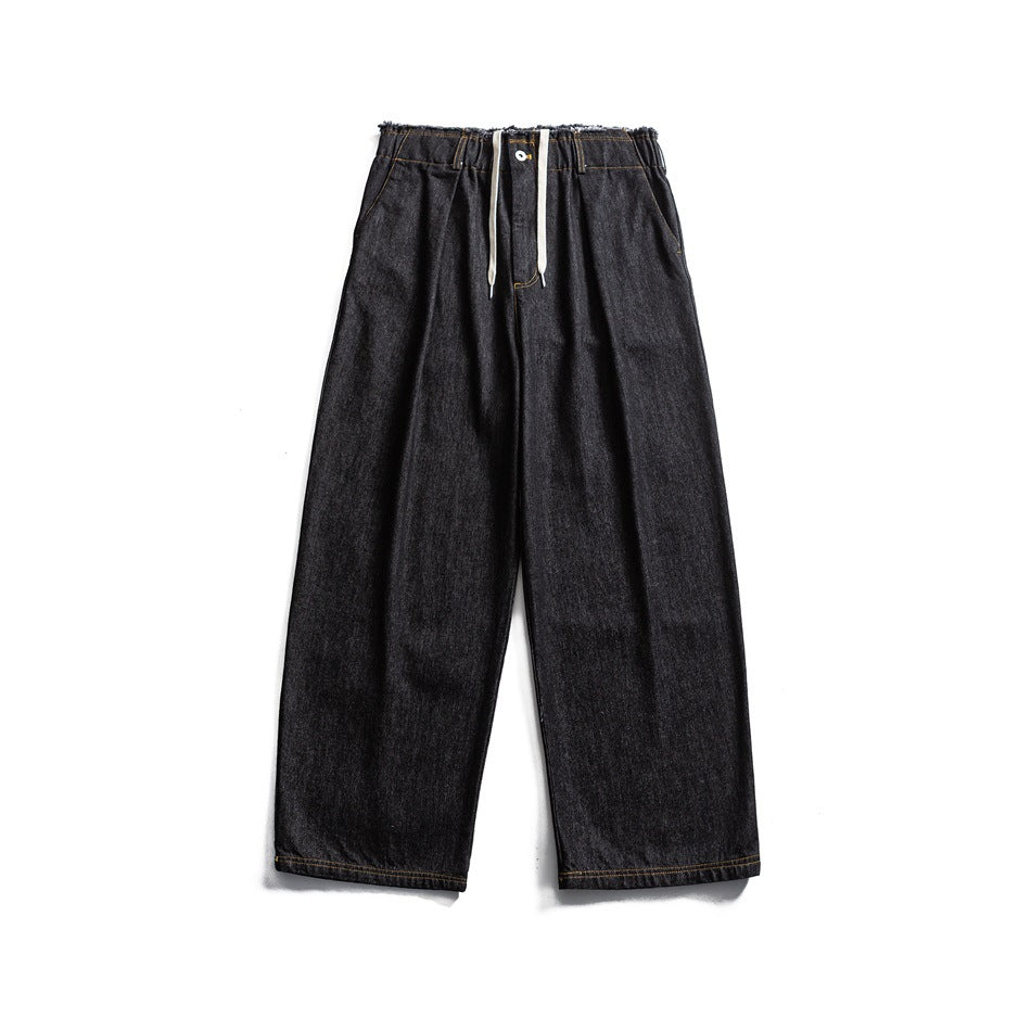 Black wide-leg denim jeans flat lay with frayed waistband, white drawstring and button closure