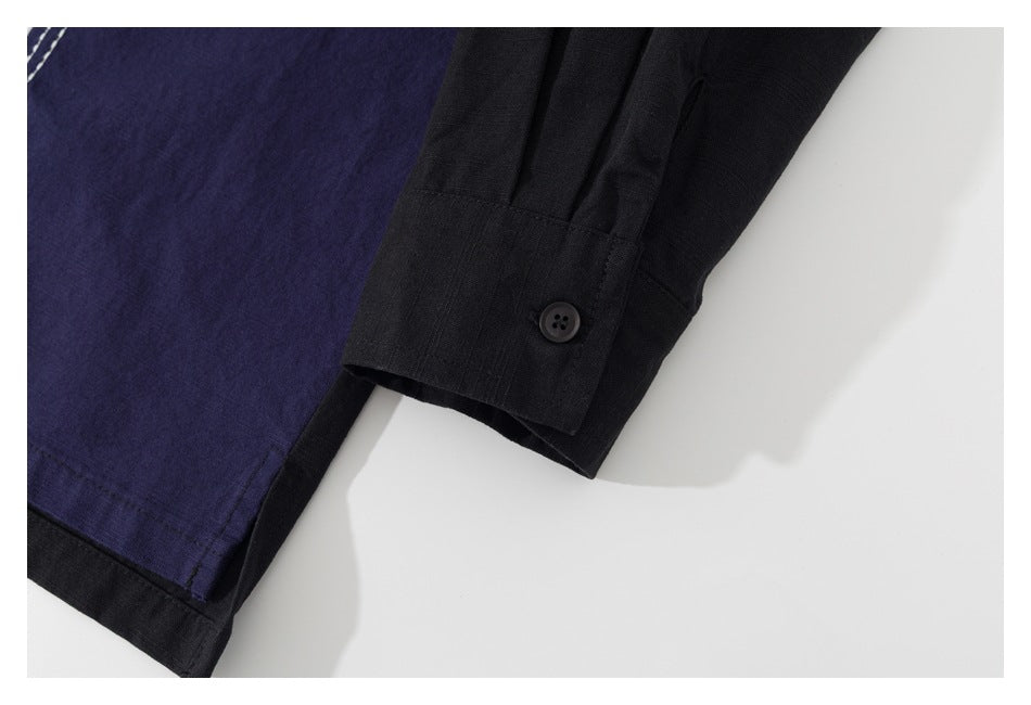 Close-up of a black buttoned cuff beside dark indigo garment fabric and black trim.