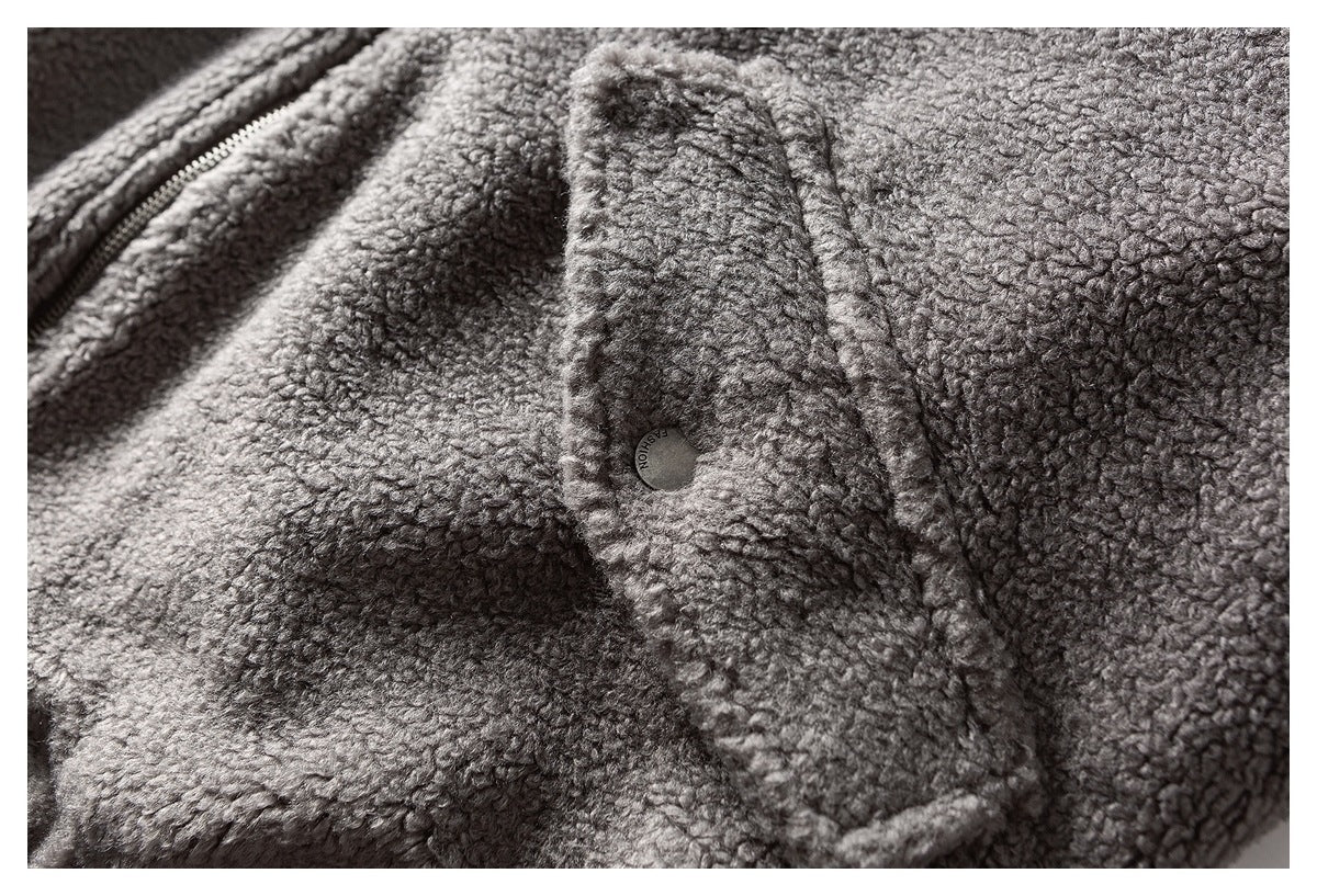 Close-up of gray textured fleece with a zipper edge and a small round snap.
