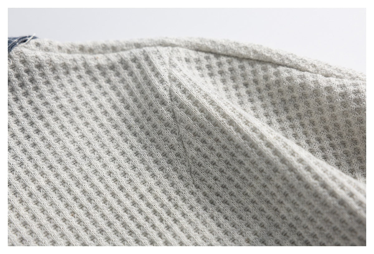Close-up showing the raised ribbed texture of light gray knit fabric.