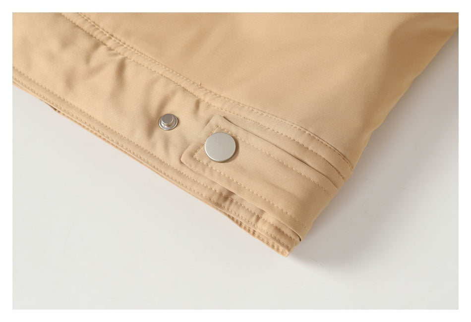 Close-up of the tan jacket hem with a snap fastener and stitched edge.