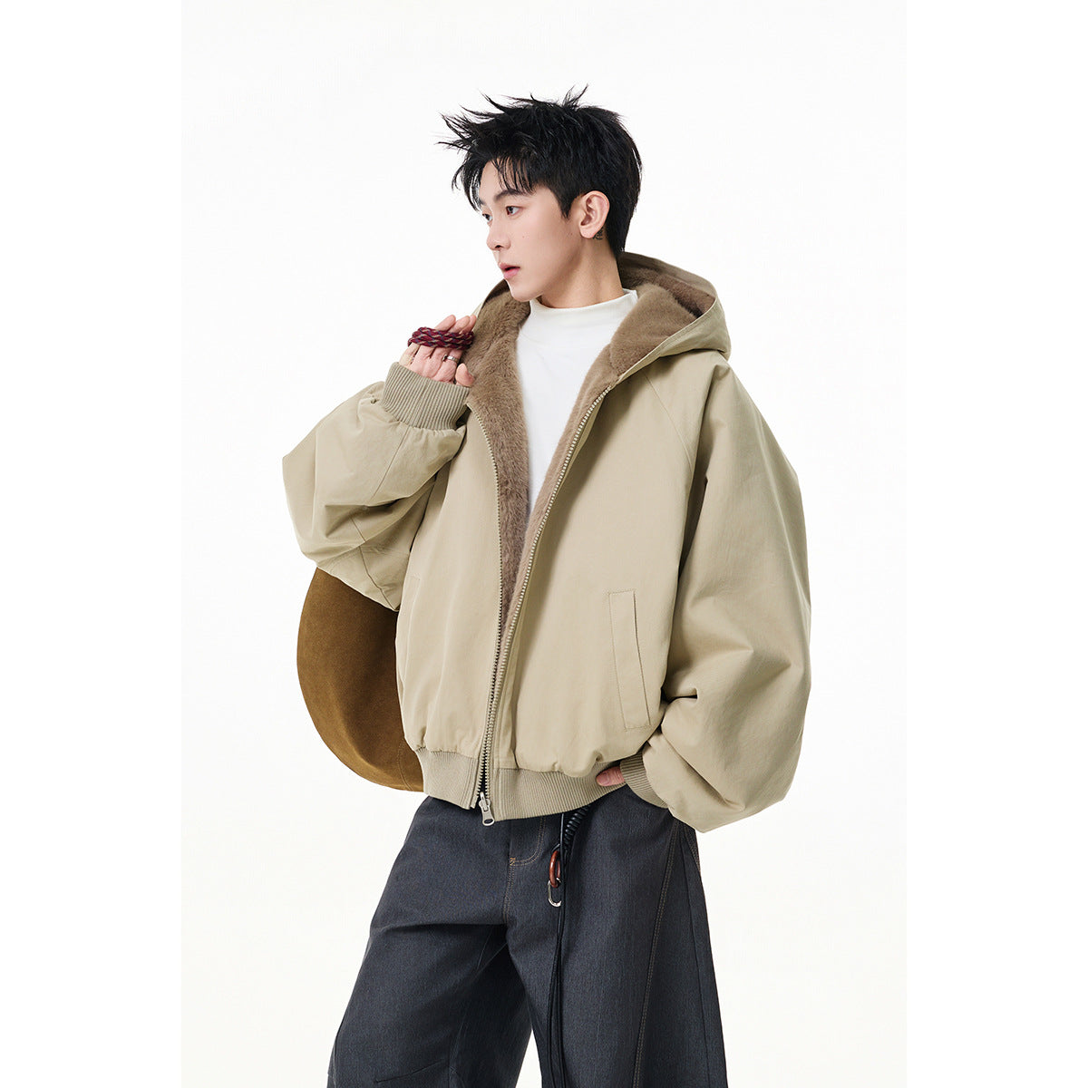 Model wearing a beige hooded jacket with brown plush lining, ribbed cuffs and hem, and a front zipper.