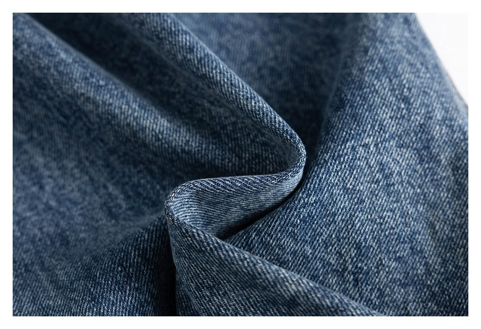 Macro view of the diagonal weave and texture of dark blue denim fabric.