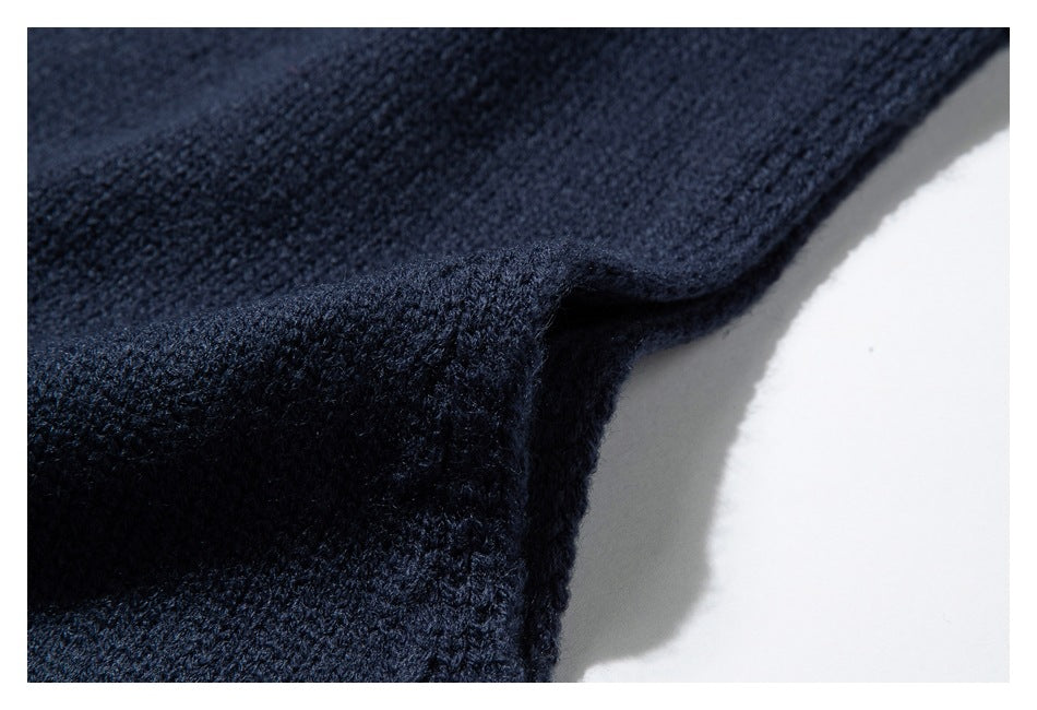 Close-up of dark navy sweater knit fabric folded at an edge.