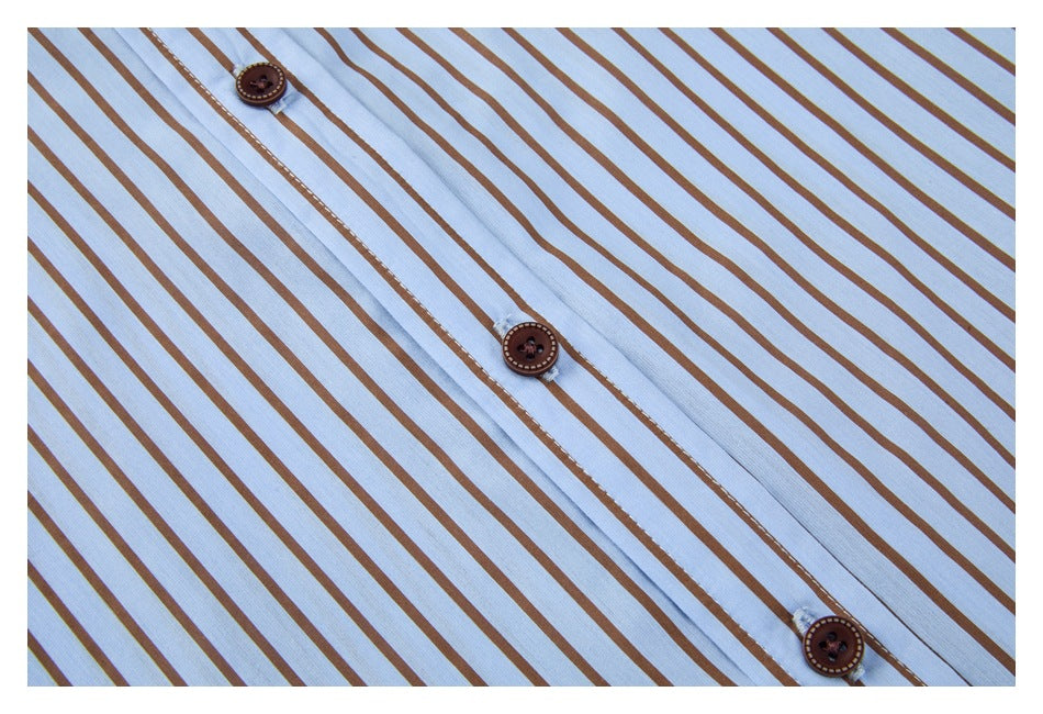 Close-up of the brown buttons and stitched placket on a light blue shirt with brown stripes.
