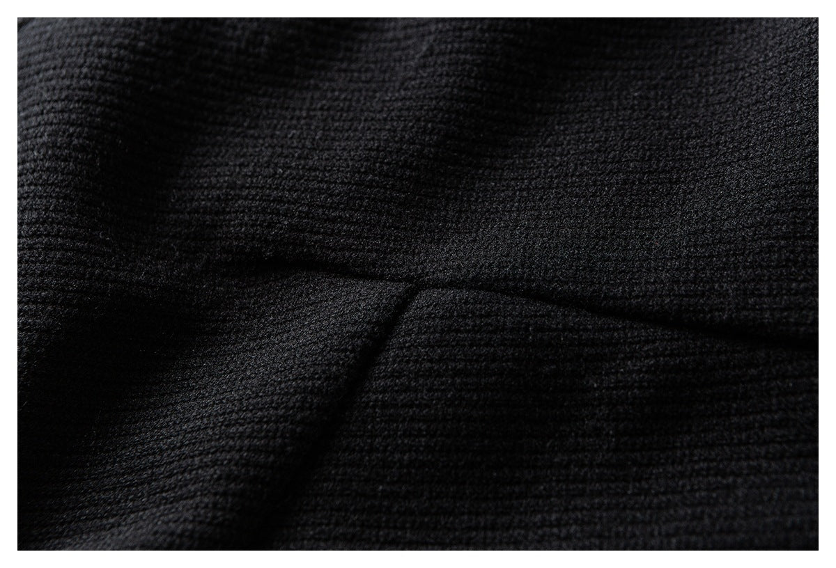 Close-up of black textured fabric and a stitched seam.