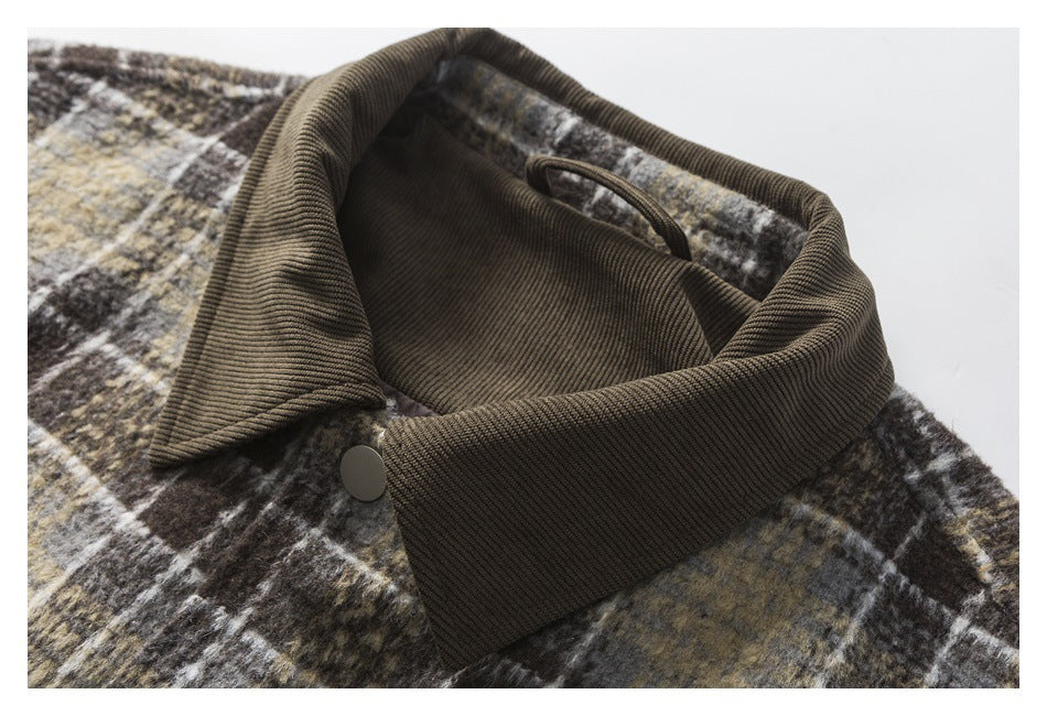 Close-up of a dark brown corduroy collar and snap on a muted plaid jacket.