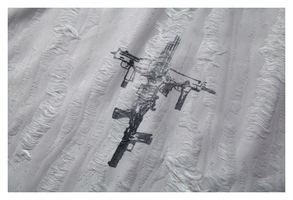 Close-up of distressed black rifle graphics printed on the light gray textured fabric.