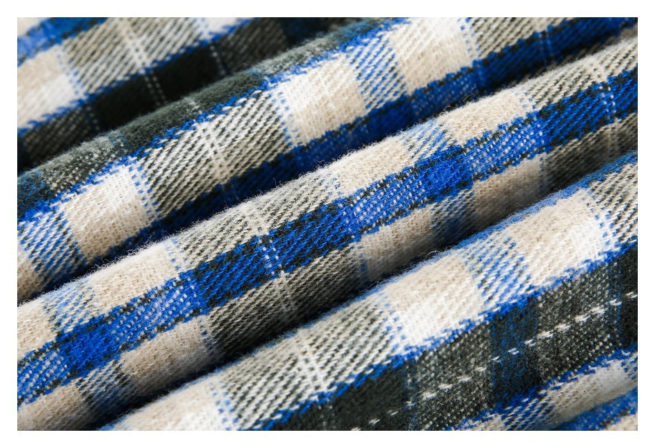 Macro view of the woven blue, black, and cream plaid fabric with raised folds.