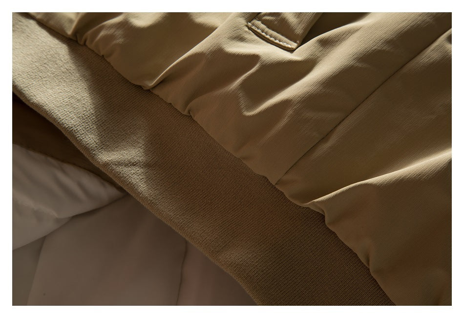 Close-up of a tan jacket edge and wide ribbed knit hem.
