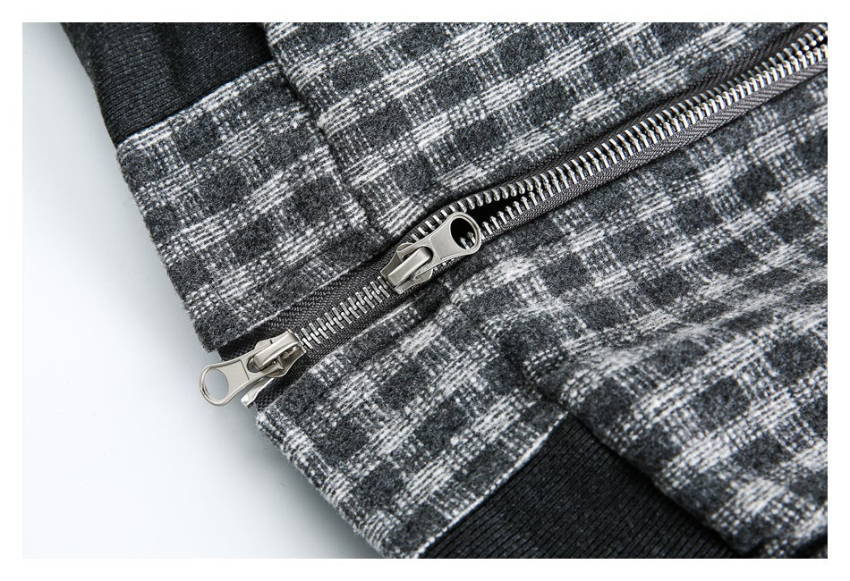 Close-up of the jacket's metal zipper with two pulls against charcoal and gray plaid fabric.
