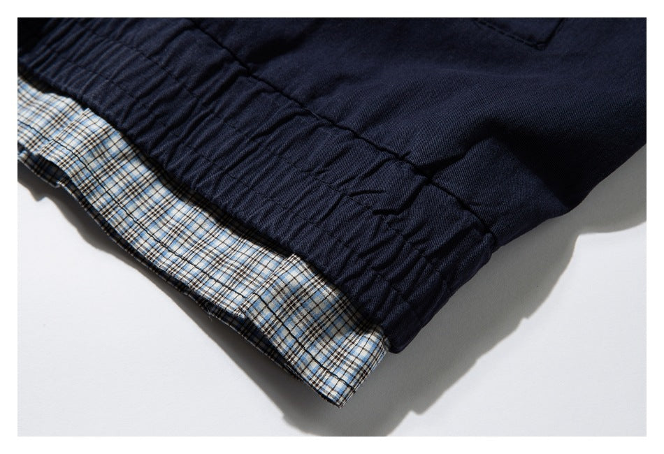 Close-up of a gathered navy garment edge with blue-and-tan plaid lining.
