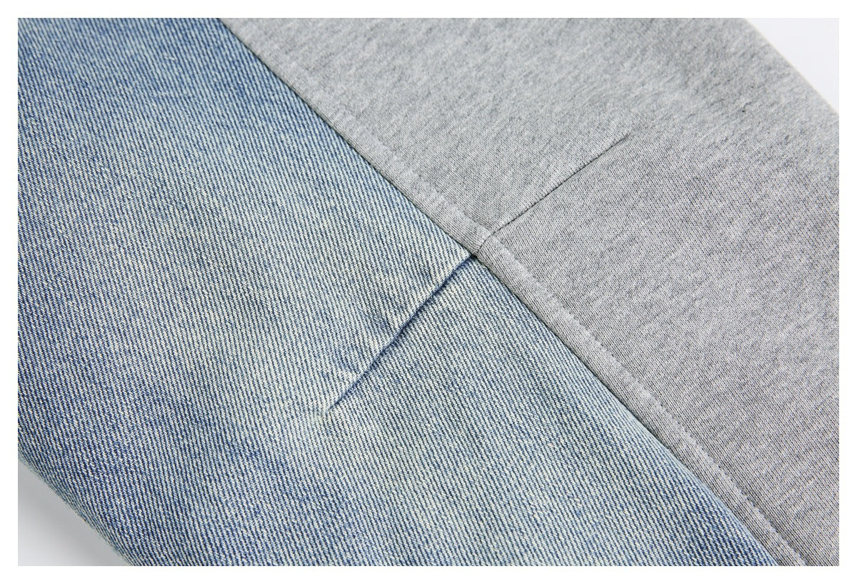 Close-up of a seam joining blue denim-like fabric and heather gray knit fabric.