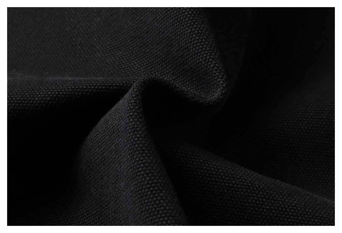 Close-up of black textured fabric gathered into folds.