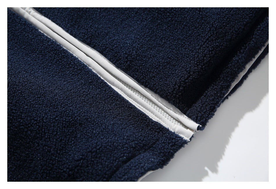 Close-up of white zipper trim along the edge of a navy fleece jacket.