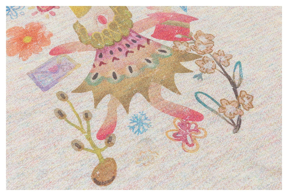 Close-up of colorful flower and abstract motifs printed on pale speckled fabric.