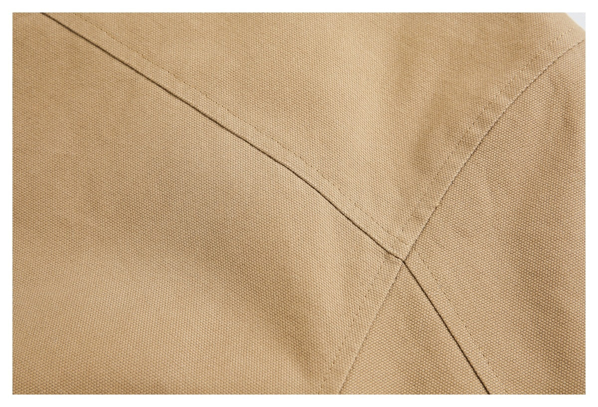 Close-up of tan woven fabric with intersecting stitched seams.