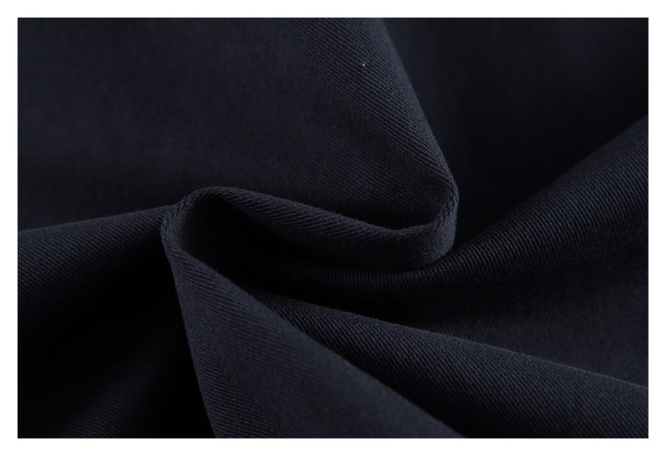 Macro view of dark navy fabric folded to show its fine woven texture.