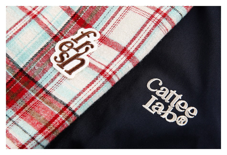 Close-up of red, teal, and white plaid beside navy fabric, with embroidered lettering on both jacket panels.