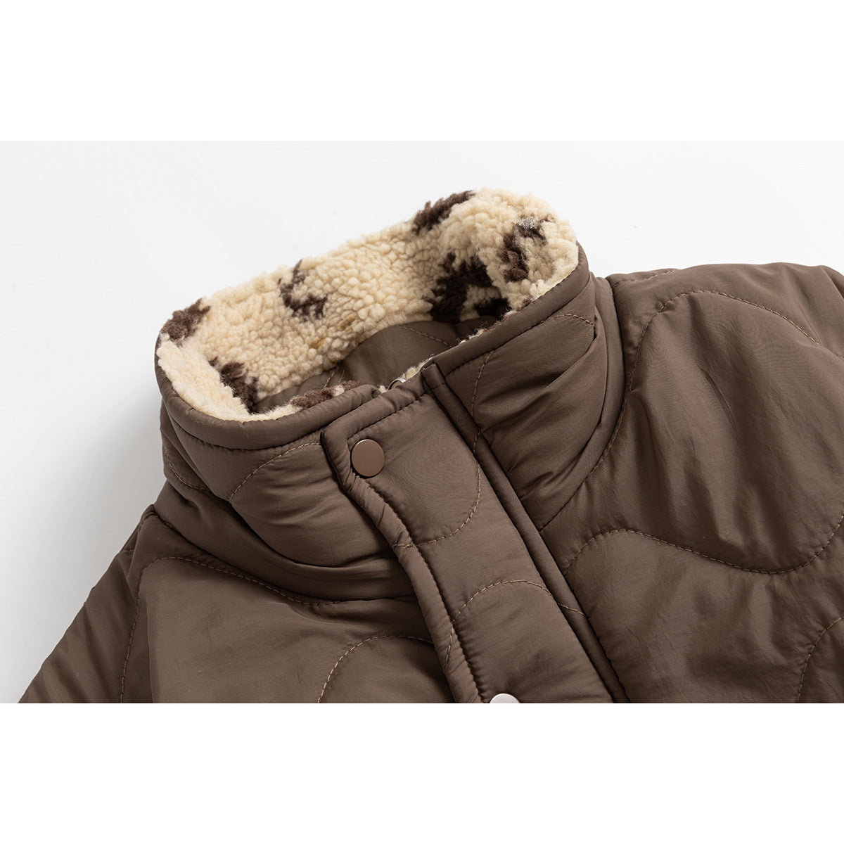 Close-up of a brown quilted jacket collar with cream-and-brown patterned fleece lining and snap-front placket.