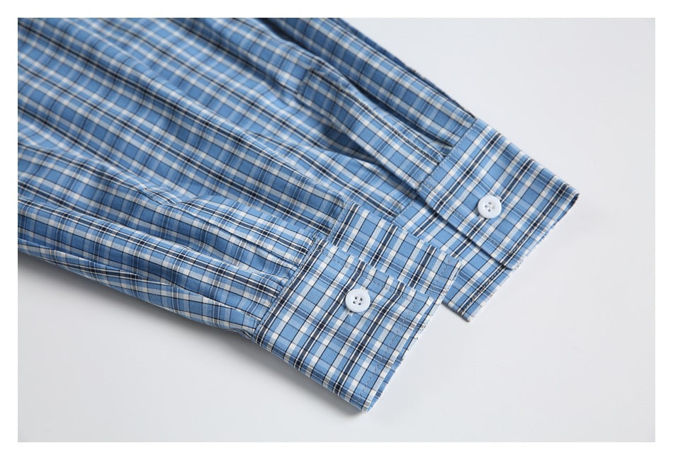 Close-up of blue plaid shirt cuffs with white buttons and button plackets.