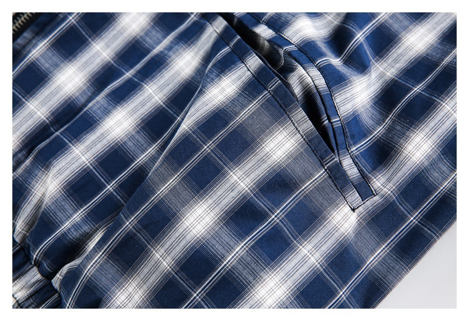 Close-up of navy and white plaid garment fabric with a stitched edge and folded opening.