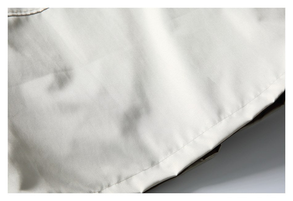 Close-up of the ivory garment's stitched lower hem.