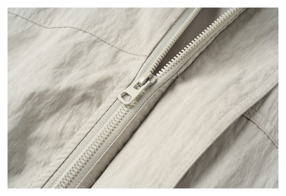 Close-up of the light beige jacket's chunky front zipper and stitched panels.